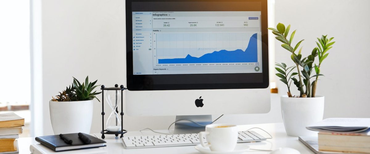 Photo by Serpstat Silver Imac Displaying Line Graph Placed on Desk